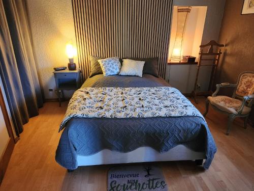 a bedroom with a bed with a blue comforter at Les Souchottes, charmante maisonnette in Bulligny