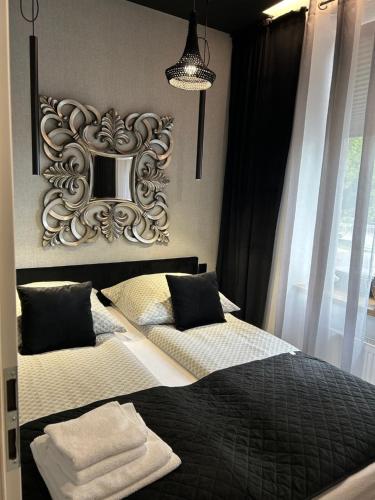 a bedroom with two beds and a mirror on the wall at Apartamenty Częstochowa pod Jasną Górą Teresy 4-2 parking gratis in Częstochowa