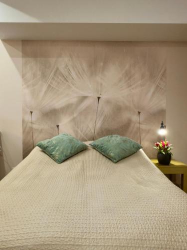 a large white bed with two pillows on it at Bracka Dom in Pabianice