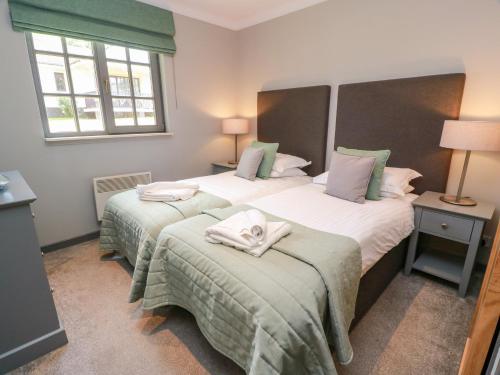 a bedroom with two beds with towels on them at 7 Brunston Avenue in Girvan