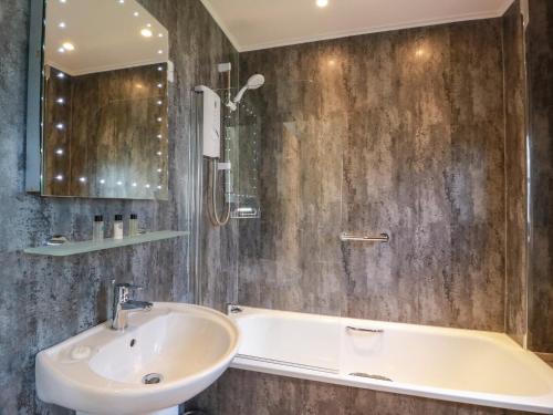 a bathroom with a sink and a bath tub at 7 Brunston Avenue in Girvan
