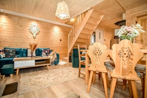 a living room with a couch and a table and chairs at Domek u Hanci Pod Gubałówką z Jacuzzi in Ząb