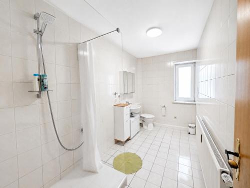 a white bathroom with a shower and a toilet at Urlaubsmagie Ferienwohnung Wiesengrün - direkt am Wanderweg - für 6P - W6 in Sebnitz