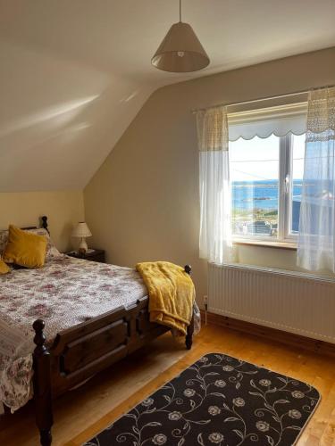 a bedroom with a bed and a large window at Teach na hAirde in Carna
