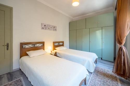 zwei Betten in einem kleinen Zimmer mit grünen Schränken in der Unterkunft teris123 in Florina