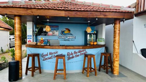 a bar with stools in front of a bar at Surf Wave Hotel in Arugam Bay