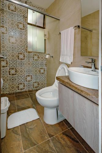 a bathroom with a toilet and a sink at Finca los Colores Villavicencio in Villavicencio