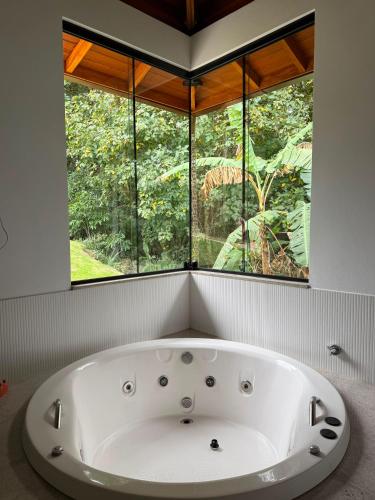 a bath tub in a bathroom with a window at A Casinha Lumiar in Lumiar
