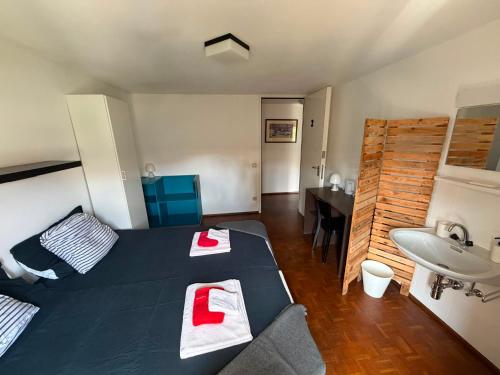 a room with a bed and a sink with towels on it at La Locanda del Viandante in Mendrisio