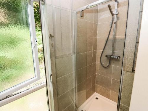 a bathroom with a shower with a glass door at Dales Retreat in Skipton