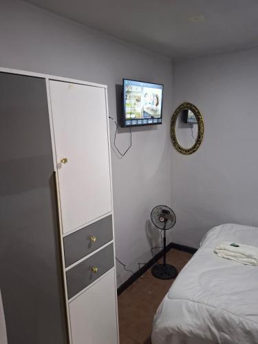 a bedroom with a bed and a dresser and a tv at Elimisam cabin in Kitwe