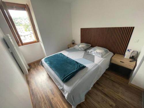 a bedroom with a bed with a blue blanket on it at Appartement Mende 2 Chambres Canapé lit WIFI Gratuit in Mende