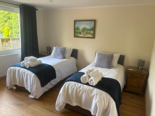 two beds with towels on them in a bedroom at The Owlery in Fort William