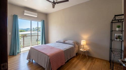 a bedroom with a bed and a large window at Casa Congo Tamarindo in Villarreal