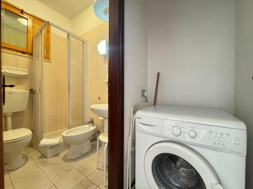 a bathroom with a washing machine and a toilet at Residenza Emilia in Lido degli Estensi