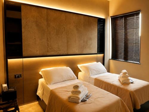 two beds in a hotel room with towels on them at Hotel PALAZZO PEPE & JACUZZI in Naples