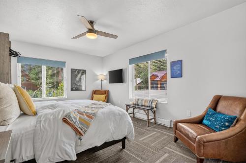 a bedroom with a bed and a chair and windows at Manor at Brighton in Brighton