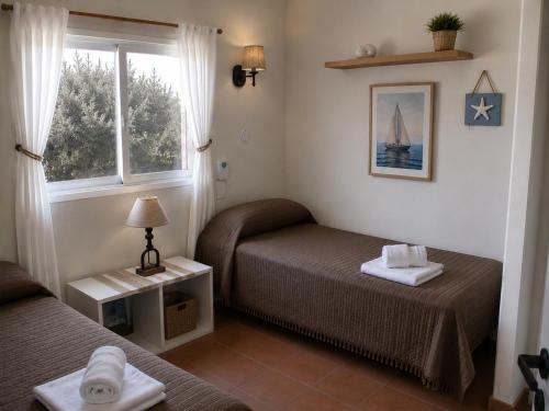 a small room with two beds and a window at Tierra Mora Casas de alquiler in Villa Gesell
