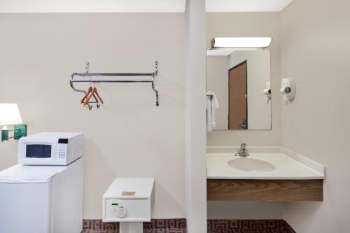 a bathroom with a sink and a microwave at Circle S Motel in Anamosa