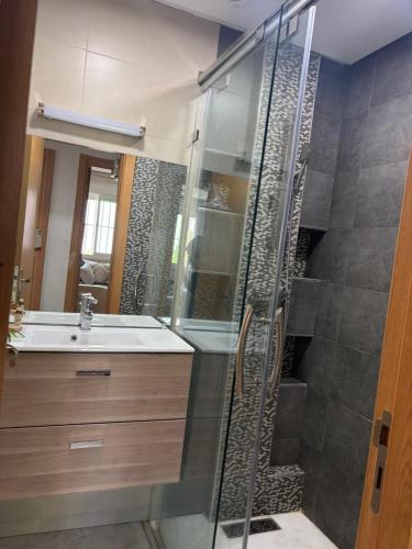 a bathroom with a shower and a sink at perle rare plage des Nations in Sidi Bouqnadel