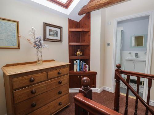 a room with a wooden dresser with a vase on it at The Spinney in Milnthorpe