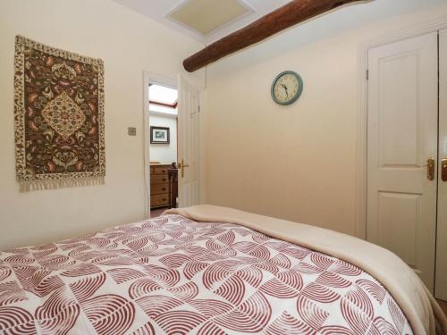 a bedroom with a bed and a clock on the wall at The Spinney in Milnthorpe