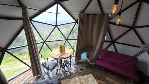 a room with a table in a igloo with a large window at Casa Domo Glamping Entre las Nubes in Santa Rosalía