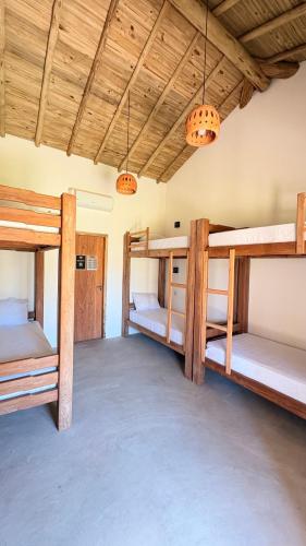 a room with three bunk beds in it at Tupinambá Pousada e Hostel in Caraíva