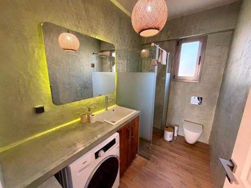 a bathroom with a sink and a mirror and a toilet at Casa Marino in Chalkida