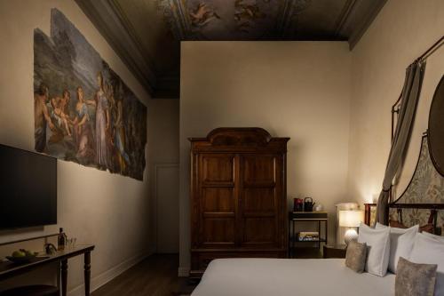 a bedroom with a bed and a painting on the wall at Porta Rossa Hotel Firenze, Colbert Collection in Florence