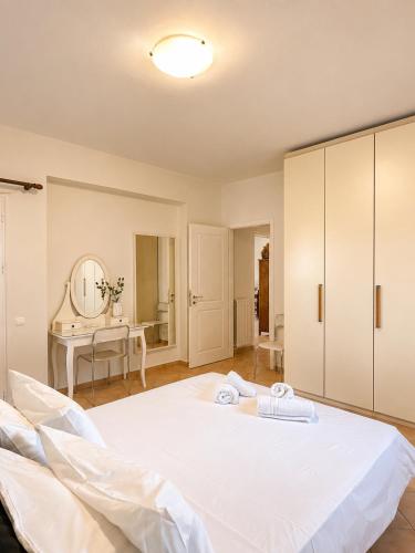 a large white bed in a room with a mirror at Seascape Nafplio Residence in Vivari