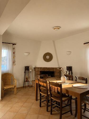 a dining room with a table and a fireplace at Seascape Nafplio Residence in Vivari