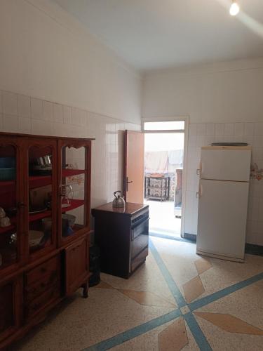 a kitchen with a refrigerator and a table in it at Dar Cadi in Safi