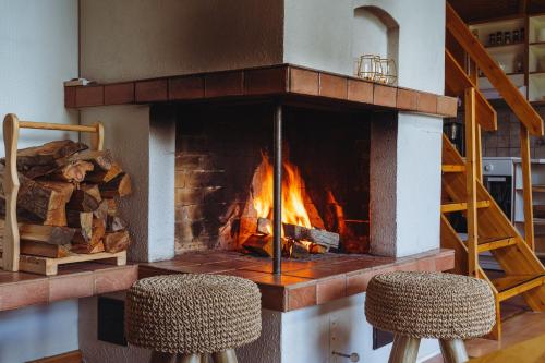 a fireplace with two chairs in front of it at Northern Nest by Elys Collection in Kittilä
