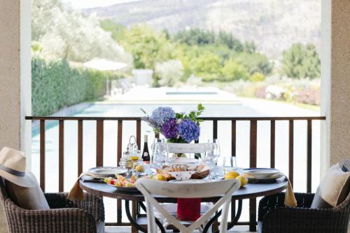 a table with food and flowers on a balcony at Casas da Memória in Tarouca