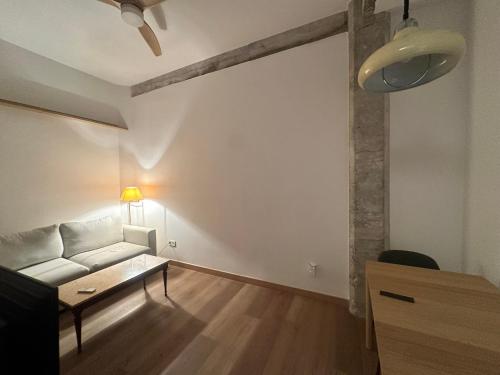 a living room with a white couch and a table at Central Bilbao, 3min walk to Guggenheim with AC in Bilbao