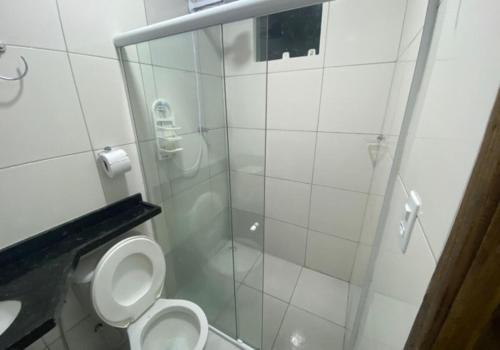 a bathroom with a toilet and a glass shower at Vila Bangalô in São José da Coroa Grande