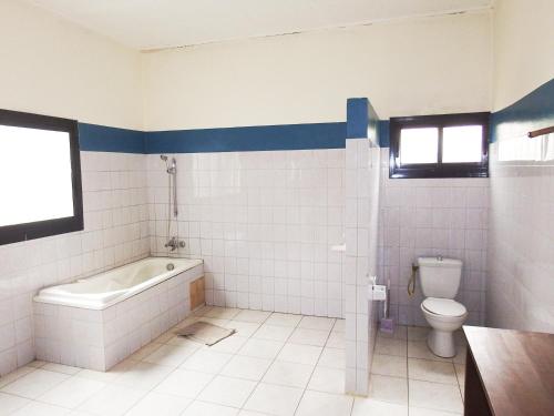 a bathroom with a bath tub and a toilet at BEAUSÉJOUR Plage in Kribi