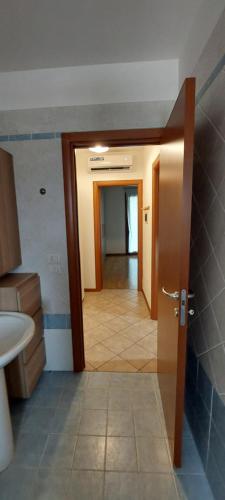 a bathroom with a door open to a hallway at Mansuè, appartamento con giardino fra Oderzo e Pordenone in Mansuè