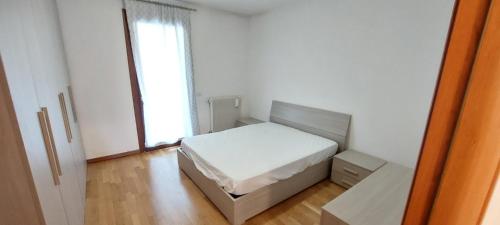 a small bedroom with a bed and a window at Mansuè, appartamento con giardino fra Oderzo e Pordenone in Mansuè