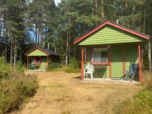 a green and red house with a chair in a yard at Longerak Camping in Bygland