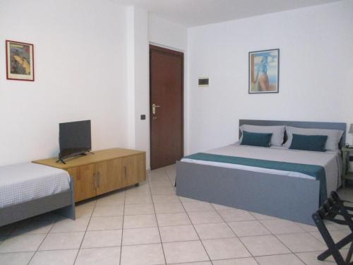 a bedroom with two beds and a television in it at Via Roma OttantaDue in Valmadrera
