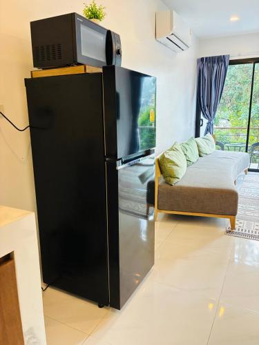 a living room with a black refrigerator and a couch at Hillside Haven-Luxury Room in Nathon Bay