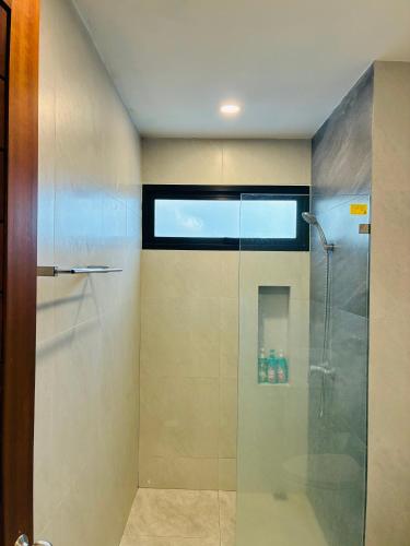 a shower with a glass door in a bathroom at Hillside Haven-Luxury Room in Nathon Bay