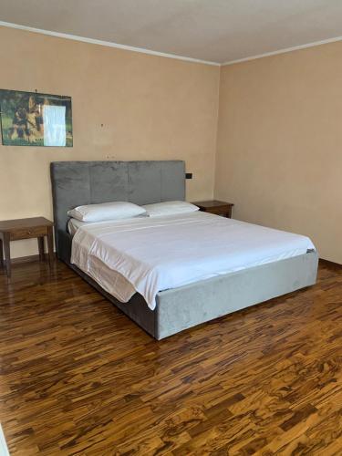 a large bed in a room with a wooden floor at La Cà di Carol Apartment in Andorno Micca