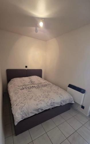 a bedroom with a bed in a white room at Studio Zeester in Westende-Bad