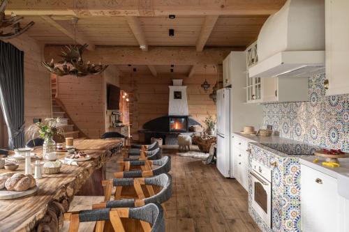 a large dining room with a long table and chairs at Bajkowa LUX Magiczne Domki z Jacuzzi in Murzasichle
