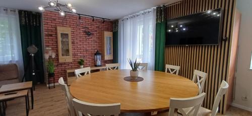 a dining room with a wooden table and chairs at Apartament Piastowska in Ostróda