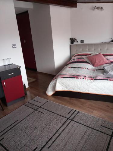 ein Schlafzimmer mit einem Bett und einem Teppich auf dem Boden in der Unterkunft Guest house Skabrin in Bansko