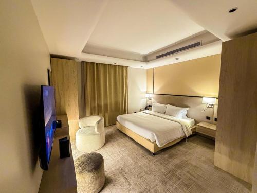 a hotel room with a bed and a flat screen tv at The Business Hotel By Seafront فندق ذا بيزنس in Jeddah